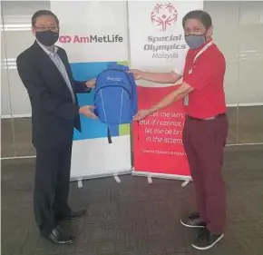  ??  ?? AmMetLife Insurance Bhd chief executive officer Lee Jiau Jiunn (left) presenting a backpack to Special Olympics Malaysia assistant secretary David Foo to signify AmMetLife and MetLife’s contributi­on to young athletes from underserve­d families.