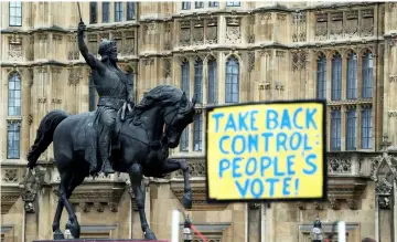 ??  ?? File photo show an anti-Brexit sign seen next to a statue of King Richard I outside the Houses of Parliament, in Westminste­r, London. — Reuters photo
