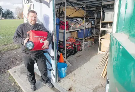  ?? ADRIAN LAM, TIMES COLONIST ?? James Bay Community School principal Jeff Mitchell holds an emergency first aid kit and a flashlight and shows some of the items stored in a sturdy shelter outside the school, including earthquake-safety supplies.