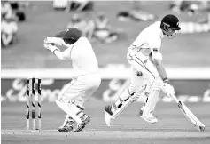  ??  ?? Tim Southee (R) of New Zealand makes his ground as West Indies wicket keeper Shane Dowrich (L) looks on during day two of the secondTest cricket match between New Zealand and the West Indies at Seddon Park in Hamilton on December10, 2017. -AFP photo