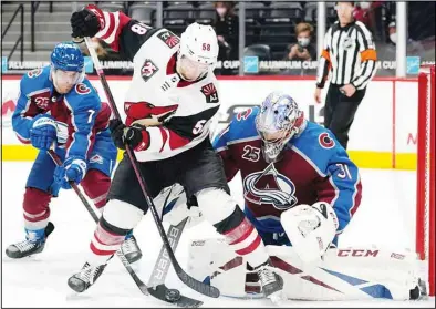  ??  ?? Colorado Avalanche goaltender Philipp Grubauer, (right), uses his stick to knock the puck away from Arizona Coyotes left wing Michael Bunting as Colorado defenseman Devon Toews defends in the third period of an NHL hockey game, on April 12, in Denver. (AP)