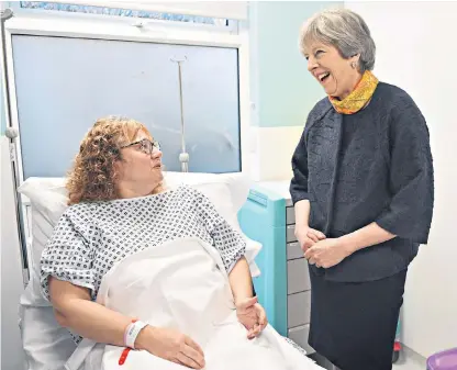  ??  ?? Theresa May talks to patient Sandra Dunn at Frimley Park Hospital in Surrey during a visit there yesterday