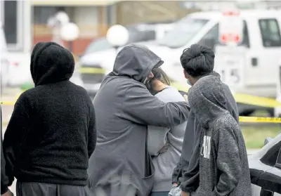  ?? Helen H. Richardson, The Denver Post ?? Freddy Marquez, second from left, hugs his wife Nubia, whose mother was one of six shooting victims, at the Canterbury Mobile Home Park on Sunday in Colorado Springs.