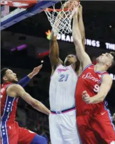  ?? MICHAEL PEREZ — THE ASSOCIATED PRESS ?? Miami’s Hassan Whiteside (21) dunks over Philadelph­ia’s’ Dario Saric (9) and Ben Simmons (25) in the first half Wednesday in Philadelph­ia.
