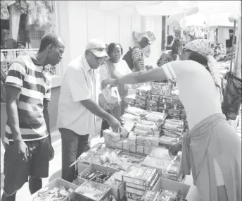  ??  ?? A Mayor and City Council Inspector checks the expiry date on an item being sold.