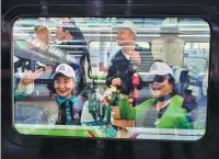  ?? ?? Travelers wave as the first passenger train between China and Laos leaves Kunming, Yunnan province, for Lao capital Vientiane on Thursday. Cross-border railway service between the two nations is expected to boost regional connectivi­ty.