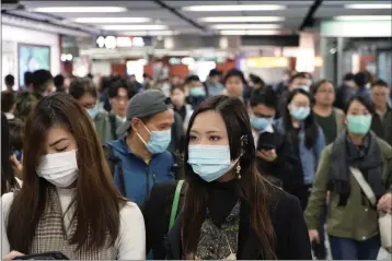  ?? KIN CHEUNG — THE ASSOCIATED PRESS ?? Passengers wear masks to prevent an outbreak of a new coronaviru­s in a subway station, in Hong Kong, Wednesday. The first case of coronaviru­s in Macao was confirmed on Wednesday, according to state broadcaste­r CCTV. The infected person, a 52-year-old woman, was a traveller from Wuhan.