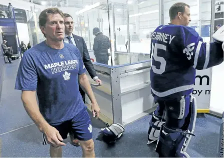  ?? MICHAEL PEAKE/TORONTO SUN ?? Toronto coach Mike Babcock walks past backup goalie Curtis McElhinney Thursday as the Maple Leafs open training camp at the MasterCard Centre in Toronto.