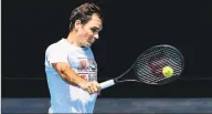  ?? William West / AFP via Getty Images ?? Roger Federer hits a return during a practice session on Saturday ahead of the Australia Open.