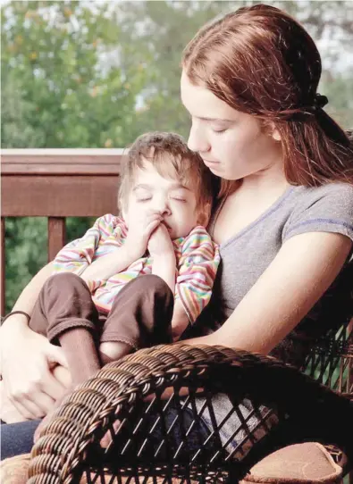  ??  ?? 20-year-old Brooke being cradled by her younger sister Carly, 17.