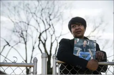  ?? MATT ROURKE—THE ASSOCIATED PRESS ?? In this Thursday, Dec. 21, 2017 photo, Trina Singleton poses for a photograph in Collingdal­e, Pa., with a photograph of her eldest son Darryl who was murdered. The Philadelph­ia Obituary Project, a new website, is working to show that homicide victims...