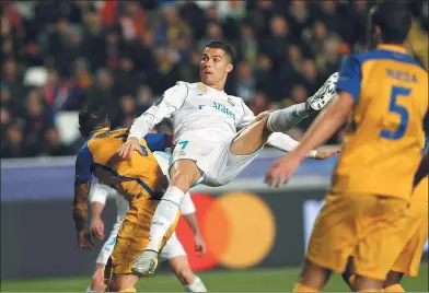  ?? PETROS KARADJIAS / AP ?? Cristiano Ronaldo acrobatica­lly nets Real Madrid’s fifth goal in its 6-0 Champions League Group H victory over APOEL Nicosia at GSP Stadium in Nicosia, Cyprus, on Tuesday.