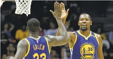  ?? DENIS POROY/ASSOCIATED PRESS ?? Kevin Durant (35), high-fiving Draymond Green, is part of a high-octane Warriors team that opens the season Tuesday.