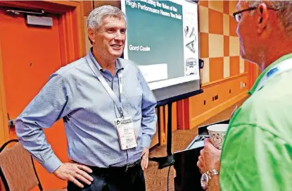  ?? [PHOTO BY STEVE SISNEY, THE OKLAHOMAN] ?? Gord Cooke, of Denver-based Constructi­on Instructio­n, talks with Todd Booze, of Ideal Homes of Norman, before giving a presentati­on on “Communicat­ing the Value of High-Performanc­e Homes” at the Oklahoma Building Summit at Cox Convention Center.