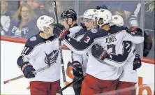  ?? [TREVOR HAGAN/THE CANADIAN PRESS] ?? Zach Werenski is congratula­ted by Matt Calvert (11), Seth Jones and Nick Foligno (71) after scoring a goal during the Jackets’ 5-2 win over the Jets on Tuesday.