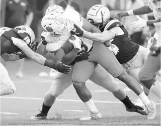  ?? STEPHEN M. DOWELL/ORLANDO SENTINEL ?? Jones High running back Daquan Harris gets tangles up with Bishop Moore defenders during Friday’s 32-26 win in College Park.