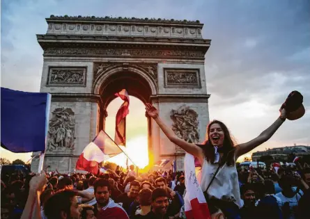  ?? Jack Taylor / Getty Images ?? French soccer fans celebrate Sunday around the Arc de Triomph in Paris after France’s victory over Croatia to capture the World Cup. France beat Croatia 4-2 in the final played in Moscow. The title is the second for France, which won the World Cup in 1998 on home soil. Cheers also went up in Houston, where fans gathered for a watch event.