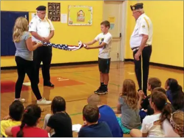  ?? TAWANA ROBERTS — THE NEWS-HERALD ?? Madison Avenue Elementary fifth-graders Joshua Frankboner and Morgan Mokwa folding the American flag during a flag etiquette class on Sept. 21.