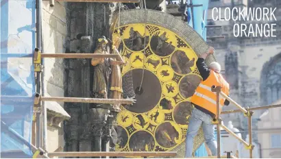  ?? Picture: AFP ?? Clockmaker Petr Skala removes the calendar dial of Prague’s medieval astronomic­al clock (Prazsky orloj), during the ongoing renovation of the Old Town Hall in Prague yesterday. The clock was installed in 1410.