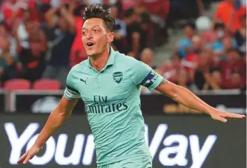  ?? AFP ?? ■ Mesut Ozil of Arsenal celebrates after scoring during the Internatio­nal Champions Cup match against Paris Saint-Germain in Singapore yesterday.
