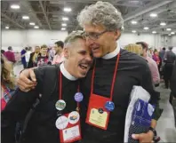  ?? AP PHOTO ?? The Rev. Michael Briggs, left, and the Rev. Ken Malcolm, right, hug after Episcopali­ans overwhelmi­ngly voted to allow religious weddings for samesex couples Wednesday, in Salt Lake City. The vote came at the Episcopal General Convention, just days...