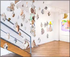  ?? ?? Katelyn Odenheimer’s porcelain hearts come together into a mobile installed along a stair at Emmanuel Gallery.