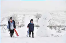  ??  ?? CHARLES MCQUILLAN/GETTY IMAGES Children climb Black Mountain with their sledges as they enjoy a day off school, Belfast, Northern Ireland.