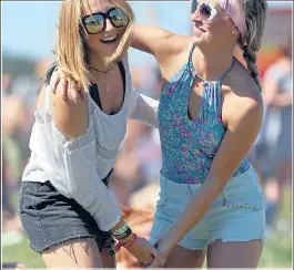  ??  ?? Two festival-goers enjoy the sunshine in Reading yesterday