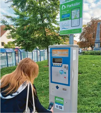  ?? Fotos: Gloria Geißler ?? Die klassische­n Parkschein­automaten wird es auch in Zukunft noch geben. Das Handy‰Parken erweitert das Angebot. Über einen QR‰Code, der an jedem Automaten angebracht ist, gelangt man direkt in den App‰Store und kann die Parkster‰App kostenlos he‰ runterlade­n. Simone Herzner zeigt, wie es geht.