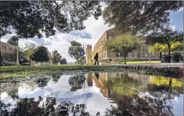  ?? Allen J. Schaben Los Angeles Times ?? A PEDESTRIAN is ref lected in standing water at UCLA in Westwood on Tuesday. The coasts and valleys can expect another inch of rain from the latest storm.