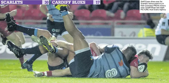  ??  ?? Steff Evans dives over for Scarlets’ bonus-point try in their Guinness PRO14 victory over Cardiff Blues last night PICTURE: Huw Evans Agency