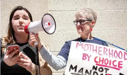  ?? NICOLE HESTER / THE TENNESSEAN ?? At Nashville’s Walk of Fame Park on Sunday, Abigail Carroll, 21, left, tells her story while Ashley Webster holds a megaphone during a protest in response to the draft SCOTUS decision on Roe v Wade.