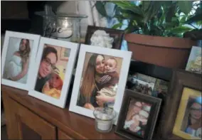  ?? MARK LENNIHAN — THE ASSOCIATED PRESS ?? In this photo, Chelsea Cobo holds her son, Christophe­r, in framed photos arranged as a shrine at her home in the Brooklyn borough of New York. Cobo disappeare­d in May of 2016. New DNA science developed to identify the skeletal remains of the 9⁄11 dead...