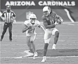  ?? MICHAEL CHOW/THE REPUBLIC ?? Cardinals receiver Larry Fitzgerald (11) catches a pass while defended by Dolphins free safety Eric Rowe on Sunday in Glendale.