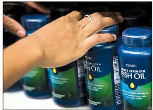  ?? Bloomberg ?? An employee organizes bottles of fish oil supplement­s at a GNC store in New York. The Food and Drug Administra­tion announced plans Monday to step up policing of dietary supplement­s, a $50 billion industry.