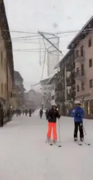  ??  ?? Sciare in centro città Sopra, turisti a spasso per il centro di Cortina e traffico in tilt. Soddisfatt­o chi frequente le piste da sci delle Dolomiti