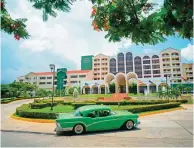  ??  ?? A vintage car passes in front of the Four Points by Sheraton hotel in Havana, Cuba.