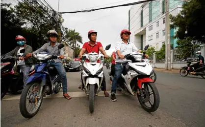  ?? —REUTERS ?? WHOYOUGONN­ACALL? Vietnam’s vigilante bikers, led by “street knight” Nguyen Thanh Hai, (right), hit the road as they patrol on the street in Thu Dau Mot City, Vietnam.