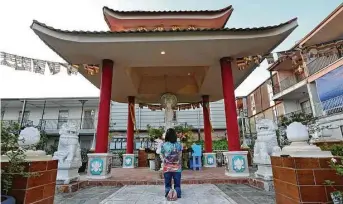  ?? Houston Chronicle file ?? A woman prays at the Buddhist Temple in the courtyard of the Thai Xuan Village.