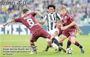  ??  ?? PEMAIN Juventus Juan Cuadrado diasak Daniele Baselli dan Cristian Ansaldi dalam perlawanan itu. -Gambar Reuters