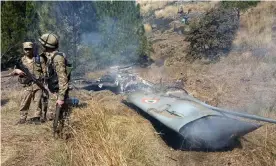  ??  ?? Pakistani soldiers stand next to what Pakistan says is the wreckage of a shot down Indian fighter jet in Pakistan-controlled Kashmir. Photograph: AFP/Getty Images