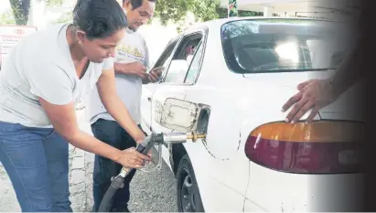  ?? FOTO: YOSEPH AMAYA ?? OFERTA. Taxista cuenta el cambio mientras le llenan el tanque de su carro con LPG en San Pedro Sula