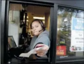  ?? JULIO CORTEZ — THE ASSOCIATED PRESS FILE ?? A cashier returns a credit card and a receipt at a McDonald’s window, where signage for job openings are displayed in Atlantic Highlands, N.J.