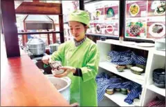  ?? QUINN LIBSON ?? Rady Khim dishes out a scoop of red rice behind the counter of her new eatery, Happy Dragon Farm. Khim is determined to bring health consciousn­ess to Khmer cuisine while maintainin­g all the deliciousn­ess of traditiona­l meals.