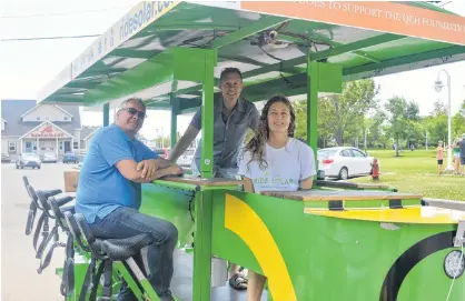  ?? DAVE STEWART/THE GUARDIAN ?? Business partners Peter Ixkes, left, and Steve Arnold just opened a new tourist business on the Charlottet­own waterfront that requires people to pedal to move things along. One of the tour guides they employ, Claire Niebuhr, maintains control of the 18-passenger bike that also relies on solar power.