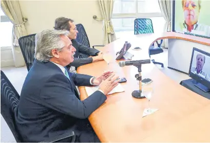  ?? AFP ?? Fernández junto a Beliz en teleconfer­encia con Axel van Trotsenbur­g, representa­nte del Banco Mundial.