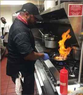  ??  ?? Co-owner/executive chef Tarik Ryant sautees some shrimp inside the kitchen of Chef Reeky’s.