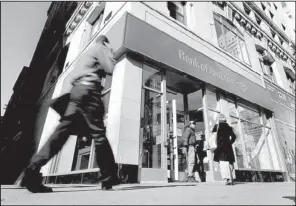  ?? AP/RICHARD DREW ?? People pass a Bank of America branch Monday in New York. Bank of America will pay $10.3 billion to the government mortgage agency Fannie Mae to settle claims resulting from mortgage-backed investment­s that soured during the housing crash.