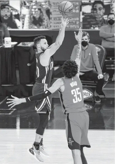  ?? Santiago Mejia / San Francisco Chronicle ?? Warriors guard Stephen Curry shoots a 3-pointer over Christian Wood in the third quarter. He finished with 18 points in the period and showcased his prowess beyond the arc with an 8-of-15 effort Saturday.