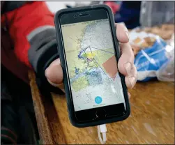  ?? Photo for The Washington Post by Jamie Cotten ?? Charles “Stormy” Mayo holds up his phone with an app that tracks whales in Cape Cod Bay.